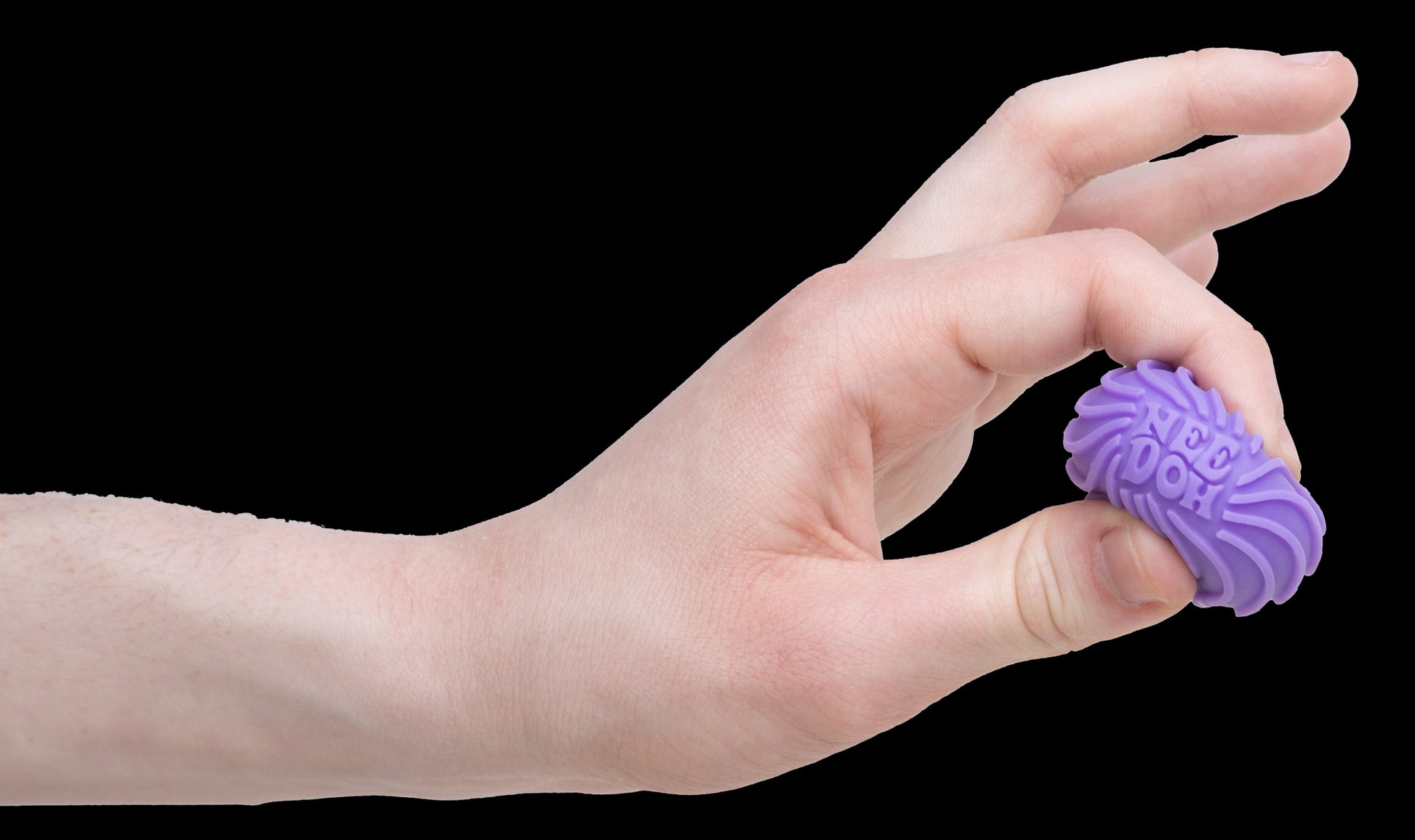 A hand is squeezing a small, purple, textured ball between two fingers. The ball's surface features wavy ridges and is called a Teenie Ripples. The background is plain white.